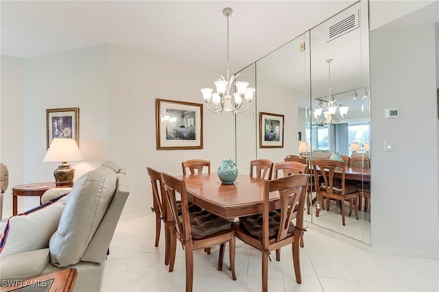 dining room with a chandelier, light tile patterned floors, and baseboards