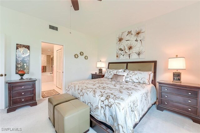 bedroom with carpet flooring, ensuite bath, and a ceiling fan