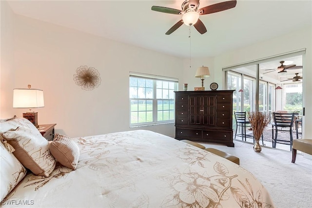 carpeted bedroom featuring access to exterior, multiple windows, and a ceiling fan