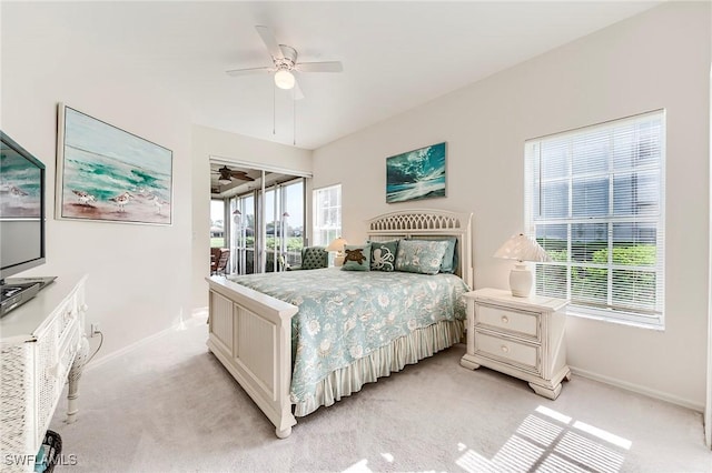bedroom featuring baseboards, access to outside, light carpet, and a ceiling fan