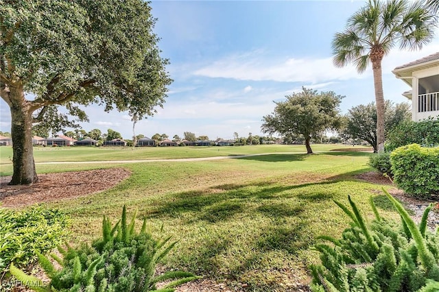 view of property's community featuring a yard and view of golf course