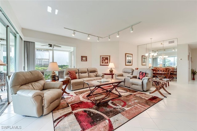 living area with light tile patterned flooring, rail lighting, a chandelier, and a ceiling fan