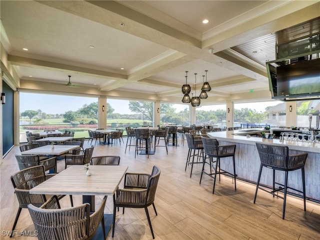 dining space with beamed ceiling, coffered ceiling, ornamental molding, light wood-type flooring, and recessed lighting