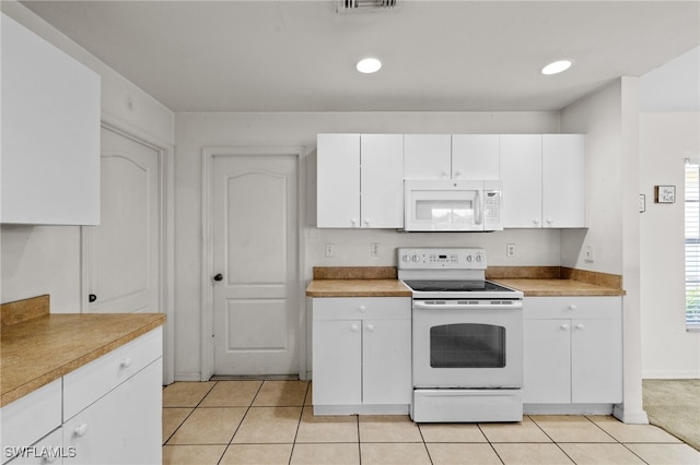 706 Kismet Pkwy E, Cape Coral, FL 33909 - kitchen with white appliances, white cabinetry, light tile patterned flooring, and recessed lighting