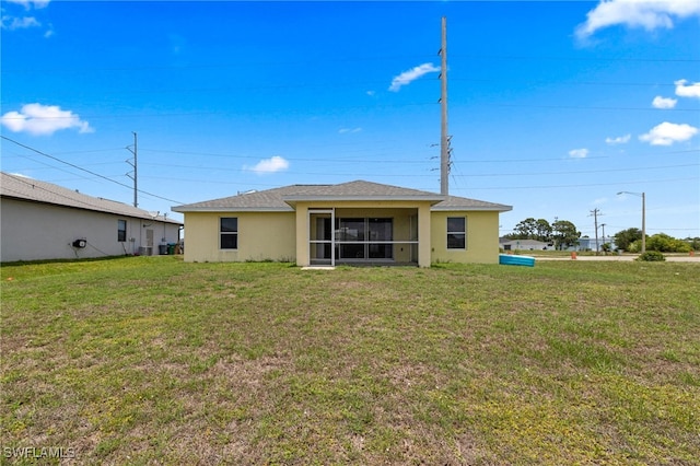 706 Kismet Pkwy E, Cape Coral, FL 33909 - back of property featuring a yard, stucco siding, roof with shingles, and a sunroom