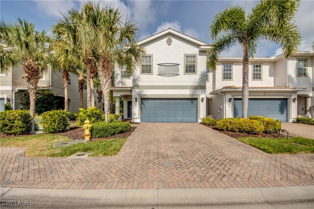 19530 Bowring Park Rd Unit 106, Fort Myers, FL 33967 - view of front of house with an attached garage, decorative driveway, stucco siding, and a balcony