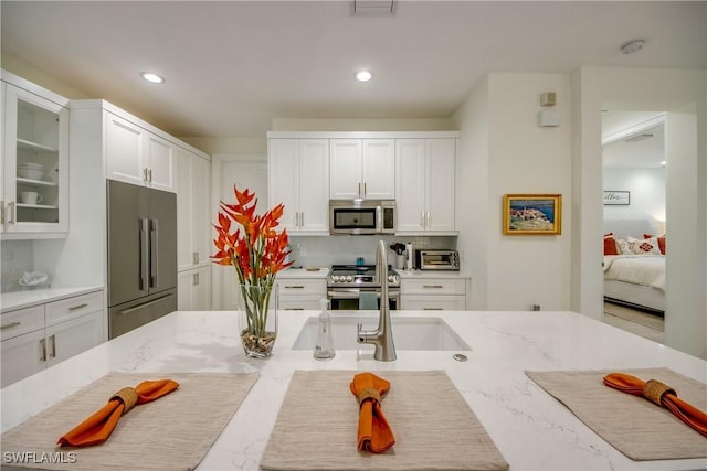 9373 Aviano Dr, Fort Myers, FL 33913 - kitchen featuring stainless steel appliances, white cabinets, decorative backsplash, glass insert cabinets, and recessed lighting