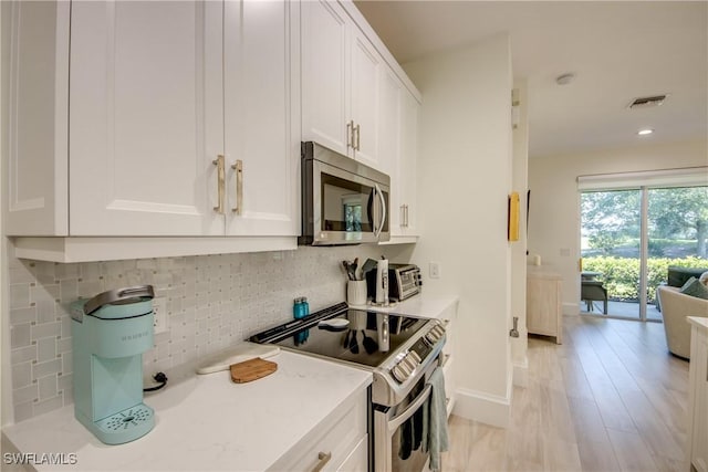 9373 Aviano Dr, Fort Myers, FL 33913 - kitchen with appliances with stainless steel finishes, white cabinets, backsplash, light countertops, and light wood-type flooring