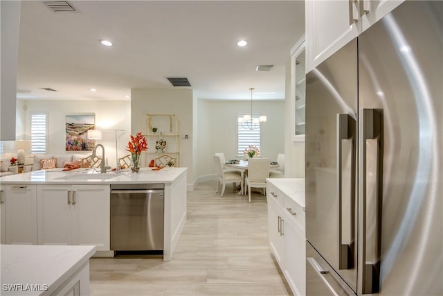 9373 Aviano Dr, Fort Myers, FL 33913 - kitchen with stainless steel appliances, white cabinetry, plenty of natural light, recessed lighting, and light stone counters