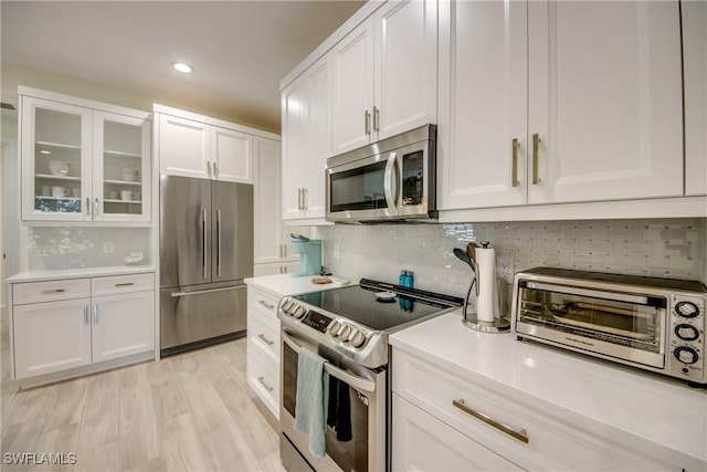 9373 Aviano Dr, Fort Myers, FL 33913 - kitchen featuring stainless steel appliances, white cabinetry, backsplash, light countertops, and recessed lighting