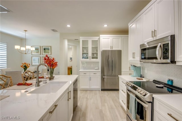 9373 Aviano Dr, Fort Myers, FL 33913 - kitchen featuring appliances with stainless steel finishes, a chandelier, white cabinetry, backsplash, and recessed lighting