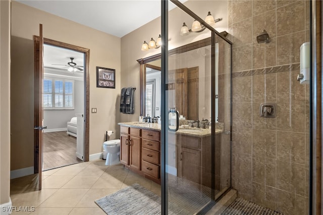 full bath with a stall shower, vanity, ceiling fan, tile patterned floors, and toilet