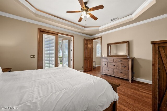 bedroom featuring a raised ceiling, wood finished floors, ornamental molding, access to outside, and baseboards