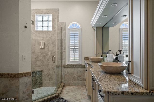 bathroom with a shower stall and double vanity