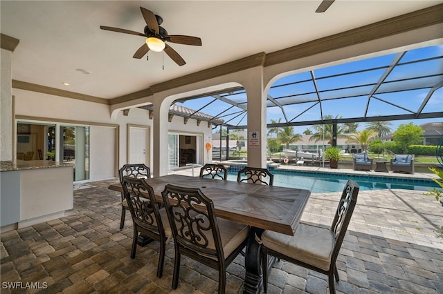 view of patio / terrace featuring ceiling fan, an outdoor pool, outdoor dining space, and a lanai