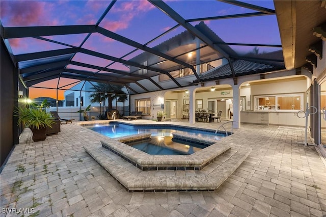 view of pool featuring a patio, an outdoor kitchen, a lanai, and a pool with connected hot tub