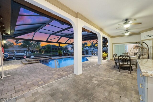 view of swimming pool with a patio, a ceiling fan, a pool with connected hot tub, and a lanai