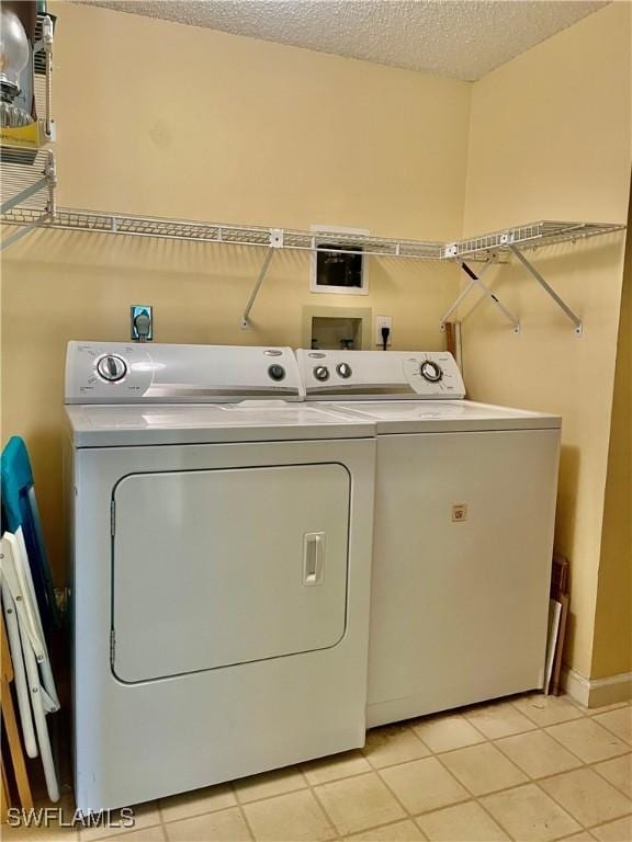 5985 Bloomfield Cir Unit D205, Naples, FL 34112 - laundry area with separate washer and dryer, light tile patterned floors, and a textured ceiling