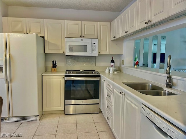 5985 Bloomfield Cir Unit D205, Naples, FL 34112 - kitchen with white appliances, a sink, light tile patterned floors, light countertops, and white cabinets