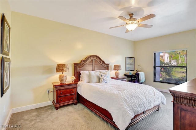 bedroom featuring light carpet, baseboards, and ceiling fan