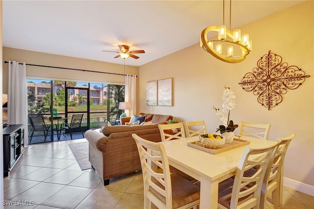 dining room featuring a chandelier, light tile patterned floors, and a ceiling fan