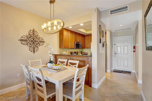 dining space with light tile patterned flooring, a chandelier, recessed lighting, baseboards, and a raised ceiling