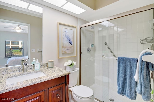 ensuite bathroom with a shower stall, vanity, toilet, and ceiling fan