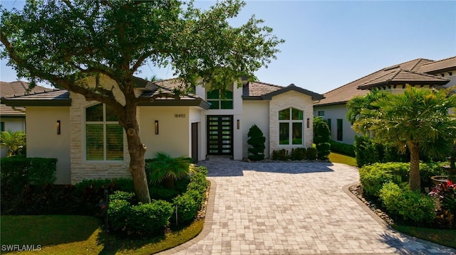 18492 Miromar Lakes Blvd W, Miromar Lakes, FL 33913 - view of front of property featuring stone siding, stucco siding, and a tile roof