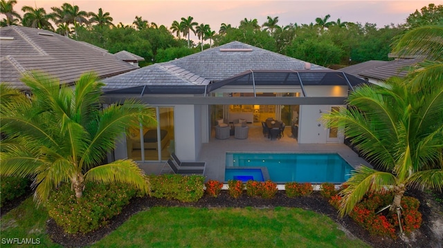 18492 Miromar Lakes Blvd W, Miromar Lakes, FL 33913 - back of property featuring a tiled roof, a patio area, glass enclosure, and a pool with connected hot tub