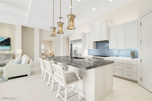 18492 Miromar Lakes Blvd W, Miromar Lakes, FL 33913 - kitchen with a sink, a breakfast bar area, open floor plan, tasteful backsplash, and an island with sink