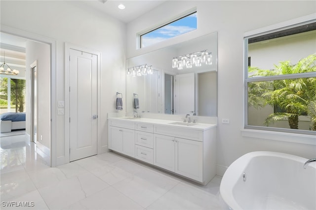 18492 Miromar Lakes Blvd W, Miromar Lakes, FL 33913 - bathroom with a soaking tub, double vanity, marble look tiles, and connected bathroom