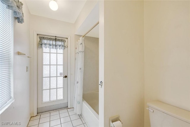 bathroom with toilet, tile patterned floors, shower / tub combo with curtain, and baseboards