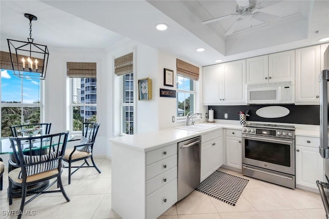 315 Dunes Blvd Unit 307, Naples, FL 34110 - kitchen featuring appliances with stainless steel finishes, a sink, ornamental molding, a chandelier, and white cabinets