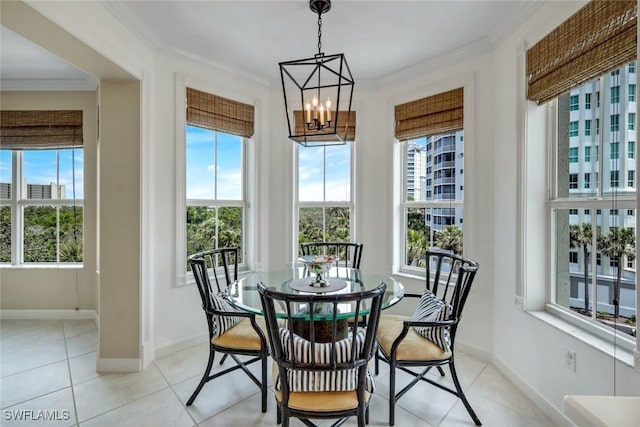 315 Dunes Blvd Unit 307, Naples, FL 34110 - dining space featuring a chandelier, ornamental molding, baseboards, and light tile patterned floors