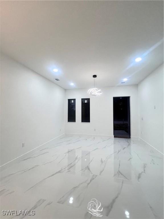 empty room featuring baseboards, recessed lighting, and light marble finish floors