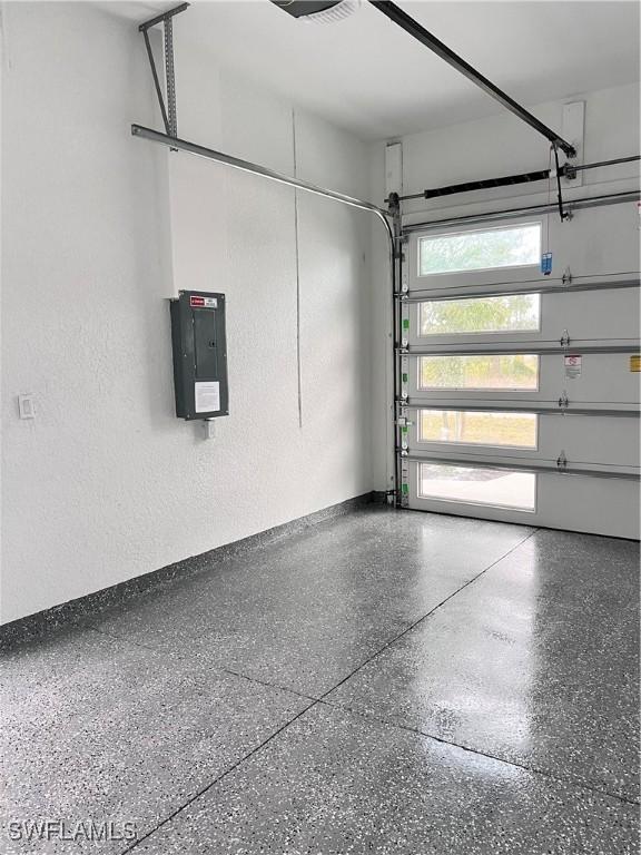 garage with electric panel and a textured wall
