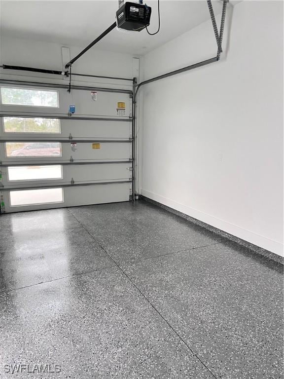 garage with a garage door opener and baseboards