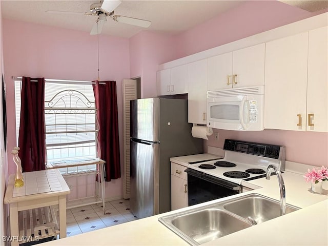 1096 Woodshire Ln Unit C205, Naples, FL 34105 - kitchen featuring white microwave, range with electric cooktop, a sink, white cabinets, and light countertops