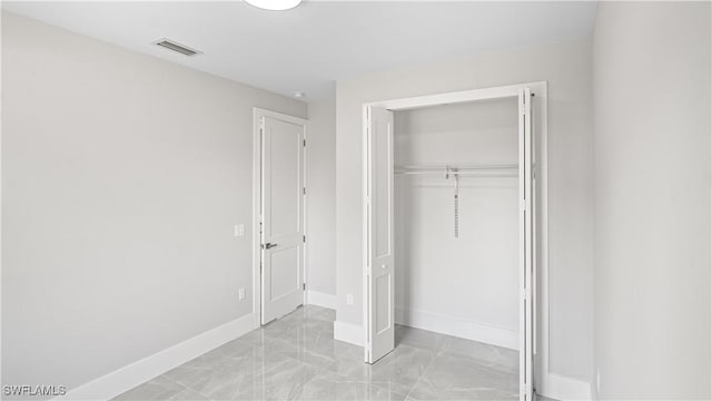 212 Connecticut Rd, Lehigh Acres, FL 33936 - unfurnished bedroom featuring light marble finish floors, baseboards, and a closet