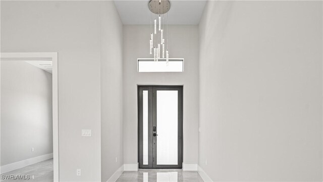 212 Connecticut Rd, Lehigh Acres, FL 33936 - entryway featuring a chandelier, baseboards, and a high ceiling