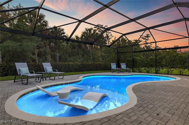 11521 Coronado Way, Naples, FL 34120 - pool at dusk featuring a patio and an outdoor pool