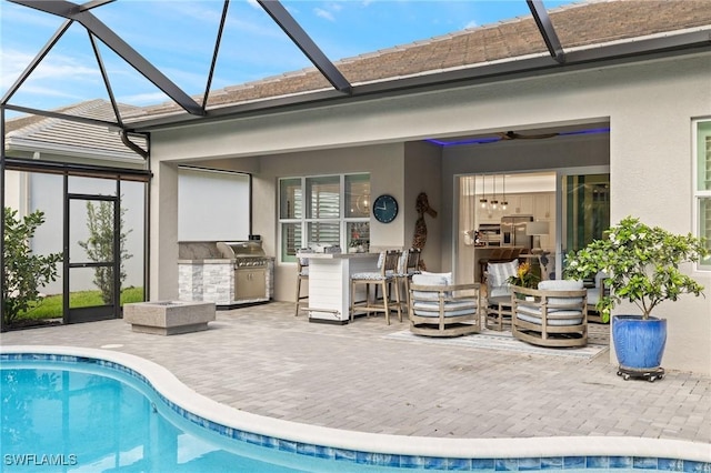 11521 Coronado Way, Naples, FL 34120 - swimming pool featuring exterior kitchen, a lanai, ceiling fan, and a patio area