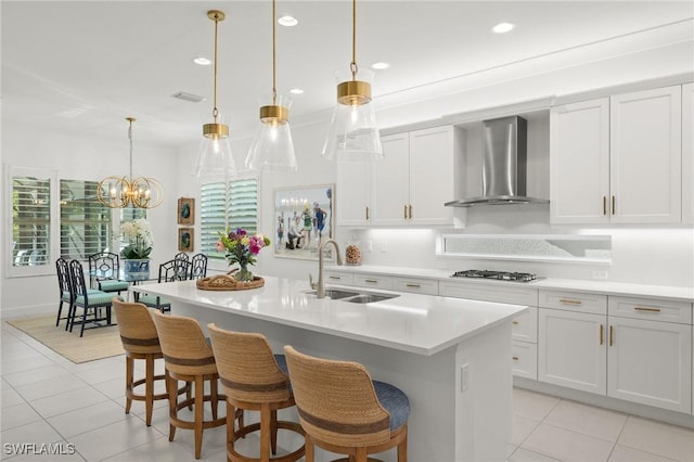 11521 Coronado Way, Naples, FL 34120 - kitchen with wall chimney range hood, a sink, stainless steel gas stovetop, light tile patterned flooring, and recessed lighting