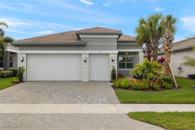 11521 Coronado Way, Naples, FL 34120 - view of front of house featuring decorative driveway, a tile roof, a garage, and stucco siding