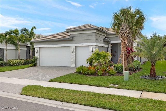 11521 Coronado Way, Naples, FL 34120 - view of front facade featuring decorative driveway, a garage, a tiled roof, a front yard, and stucco siding