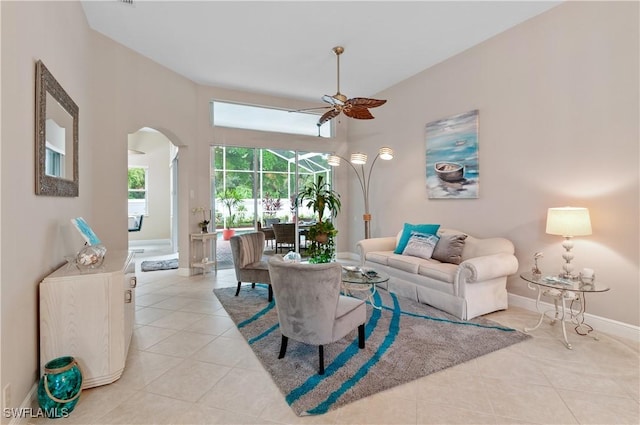 20408 Foxworth Cir, Estero, FL 33928 - living area featuring a ceiling fan, arched walkways, light tile patterned floors, and baseboards