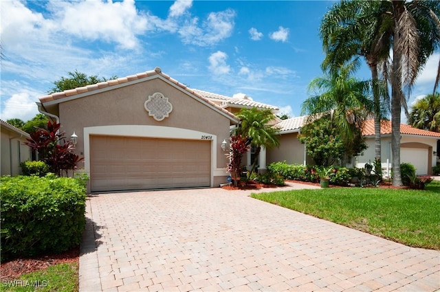 20408 Foxworth Cir, Estero, FL 33928 - mediterranean / spanish house featuring an attached garage, decorative driveway, stucco siding, and a front yard
