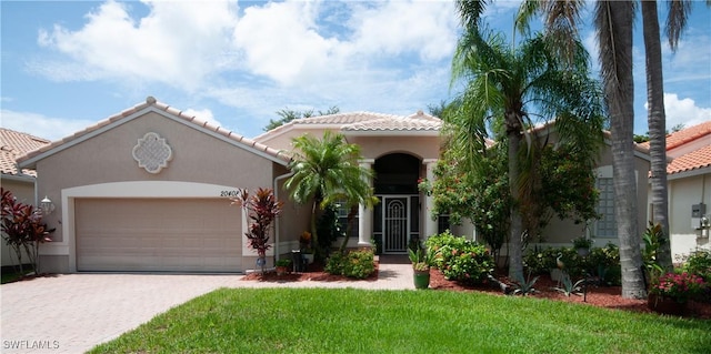 20408 Foxworth Cir, Estero, FL 33928 - mediterranean / spanish-style home with an attached garage, a tiled roof, decorative driveway, and stucco siding