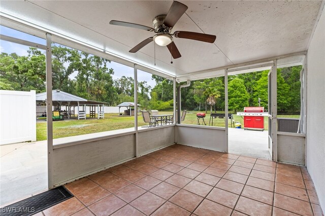 4411 Rose St, Valrico, FL 33596 - unfurnished sunroom with view of scattered trees and ceiling fan