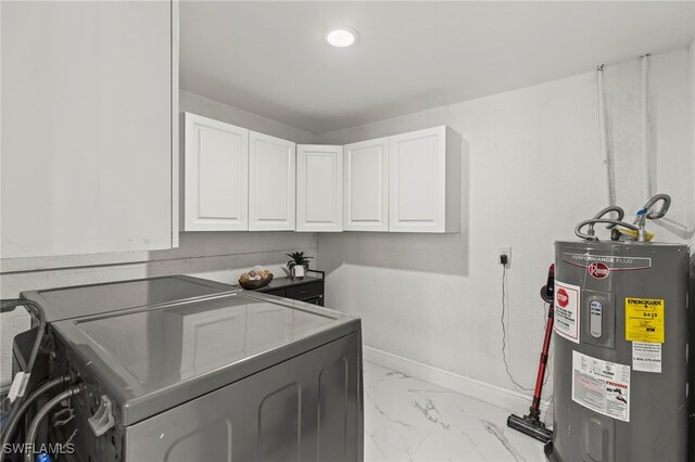 4411 Rose St, Valrico, FL 33596 - laundry area featuring washing machine and clothes dryer, cabinet space, water heater, light marble finish flooring, and baseboards